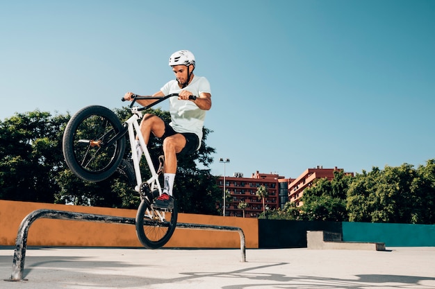 Cavaliere adolescente di bmx che esegue i trucchi nello skatepark