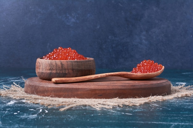 Caviale rosso su tavola di legno.