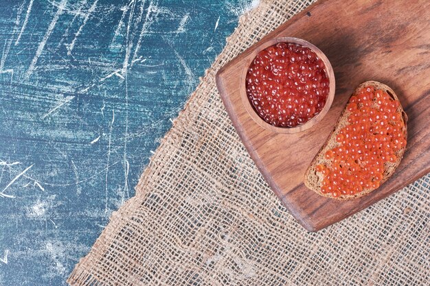 Caviale rosso su tavola di legno.