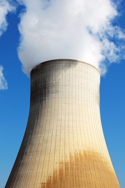 Centrale nucleare di torre di raffreddamento nel cielo blu