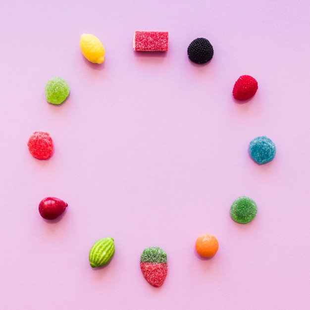 Cerchio fatto con caramelle di gelatina di zucchero sopra lo sfondo rosa