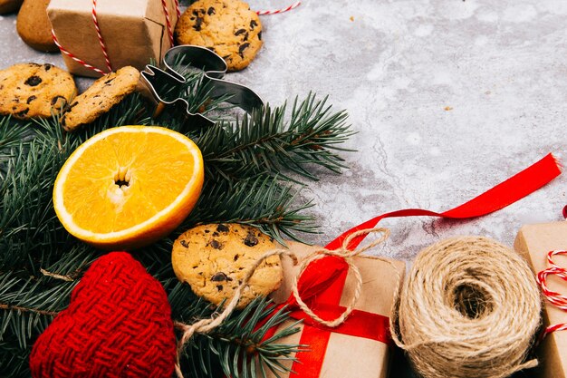 Cerchio fatto di arance, biscotti, rami di abete e scatole rosse presenti