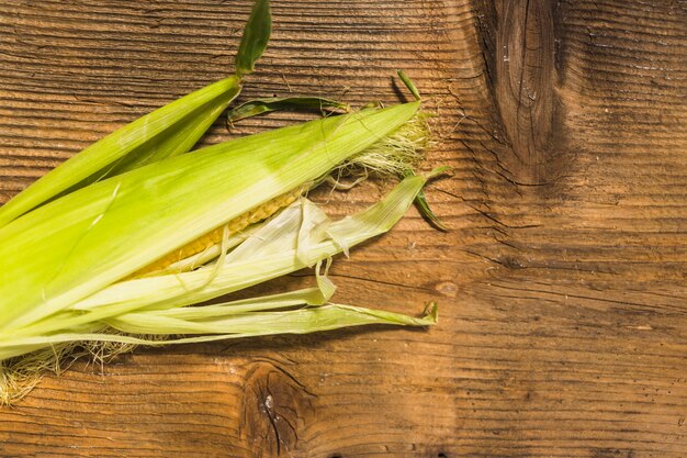 Cereale fresco sulla pannocchia contro fondo di legno