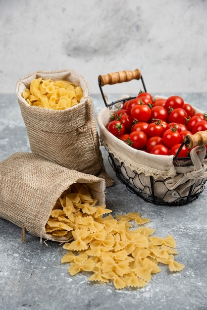 Cestini rustici di pasta con pomodorini su un tavolo di marmo.