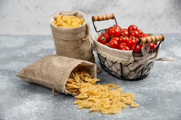 Cestini rustici di pasta con pomodorini su un tavolo di marmo.