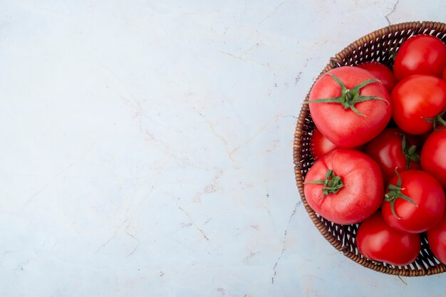 Cesto di pomodori su superficie bianca