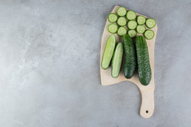 Cetrioli affettati freschi con coltello su una tavola di legno. Foto di alta qualità