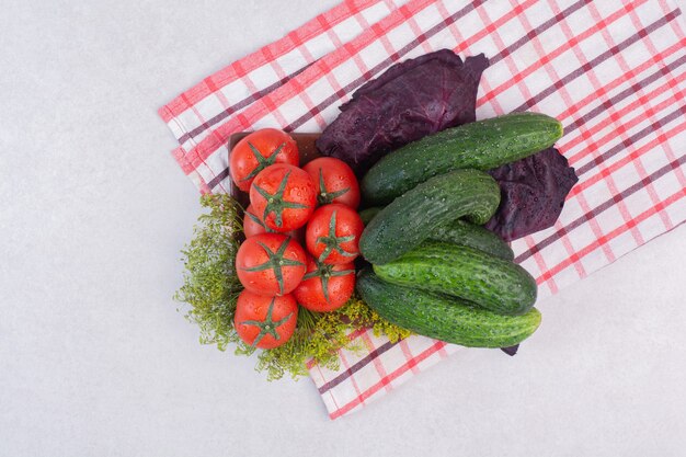 Cetrioli, verdure e pomodori sulla tovaglia.