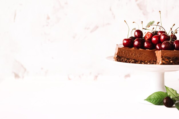 Cheesecake al cioccolato senza cottura decorata con ciliegie fresche e spazio per copiare la menta per il testo