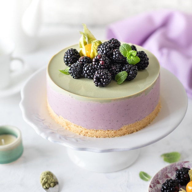 Cheesecake al cocco con cioccolato bianco al tè matcha giapponese e decorata con more