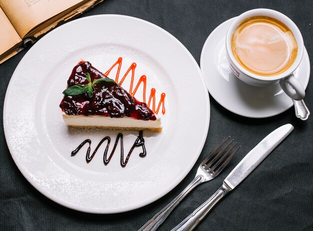 Cheesecake alla fragola vista dall'alto con una tazza di cappuccino