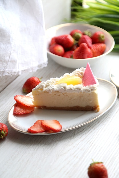 Cheesecake vista laterale con panna e fragole