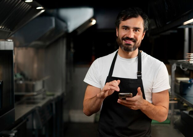 Chef che cucina in cucina indossando abiti professionali