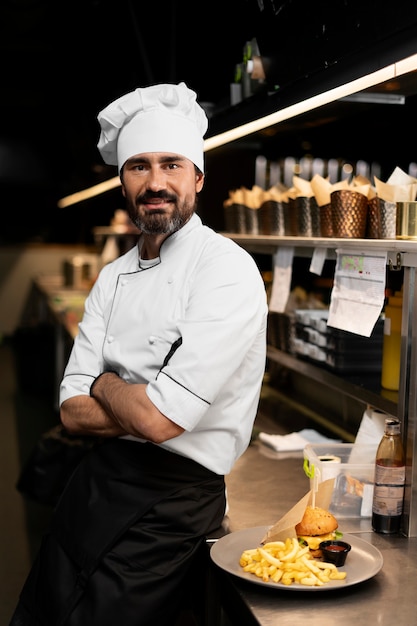 Chef che cucina in cucina indossando abiti professionali