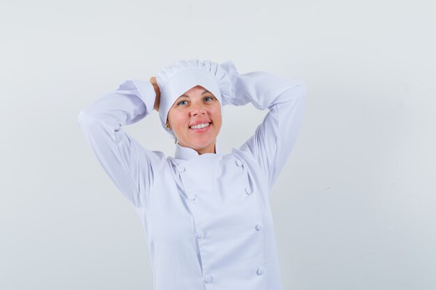 chef donna tenendo le mani sulla testa in uniforme bianca e cercando pacifica.