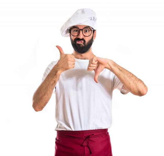 Chef facendo un segno buono-cattivo su sfondo bianco