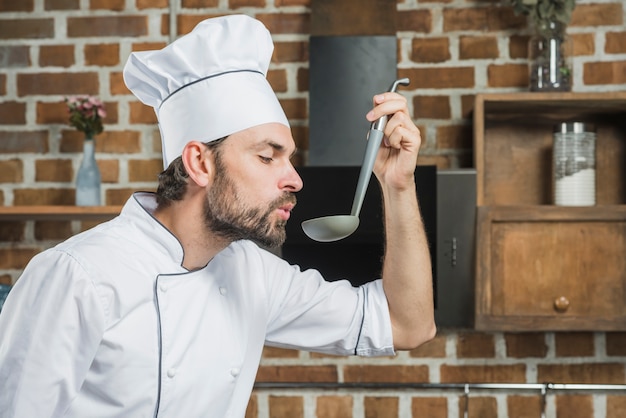 Chef godendo l&#39;aroma di una zuppa nel mestolo