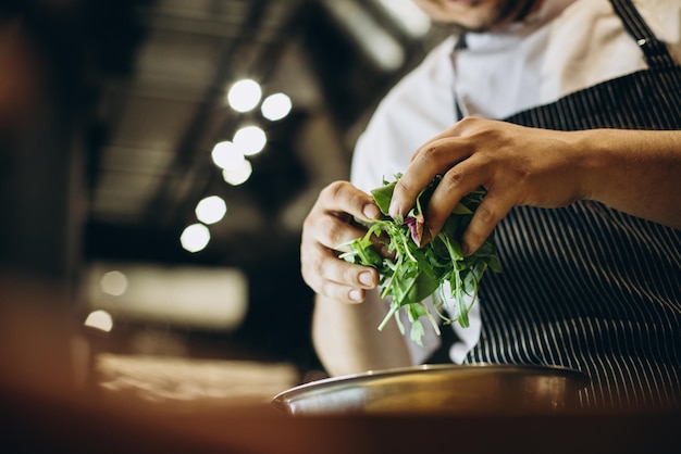 Chef in cucina a preparare l'insalata