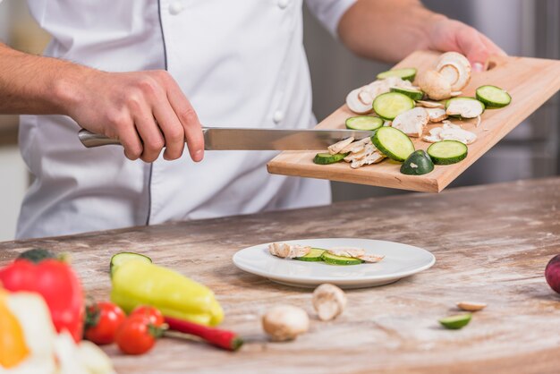 Chef in cucina cucinare con verdure