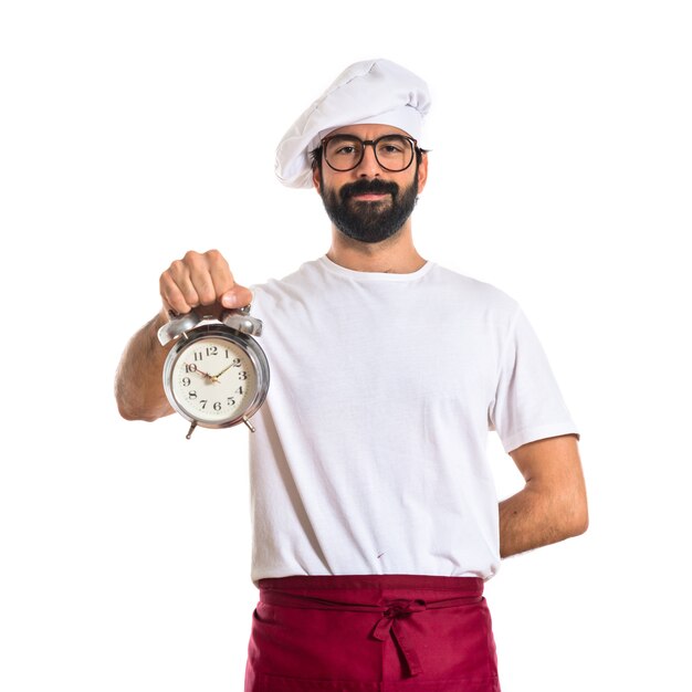 Chef in possesso di un orologio su sfondo bianco