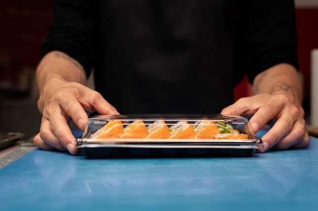 Chef maschio che prepara un ordine di sushi da asporto