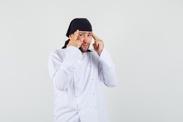 Chef maschio che soffre di emicrania cronica in uniforme bianca e sembra esausto, vista frontale.