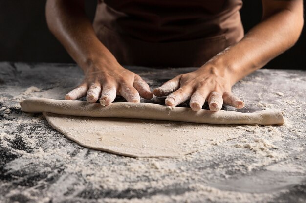 Chef stendendo la pasta con molta farina sul tavolo