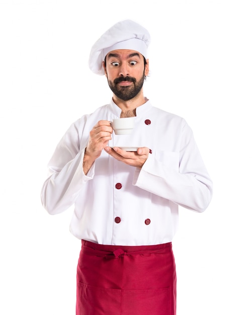 Chef tenendo una tazza di caffè su sfondo bianco