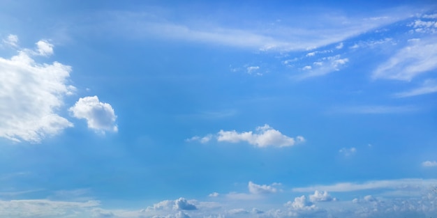 Chiaro cielo soleggiato con nuvole su sfondo blu