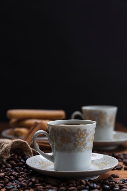 Chicchi di caffè del primo piano vicino alla tazza