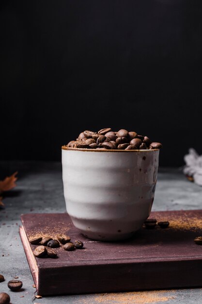 Chicchi di caffè di vista frontale in tazza