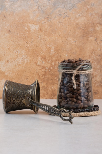 Chicchi di caffè e cezve su sfondo bianco. Foto di alta qualità