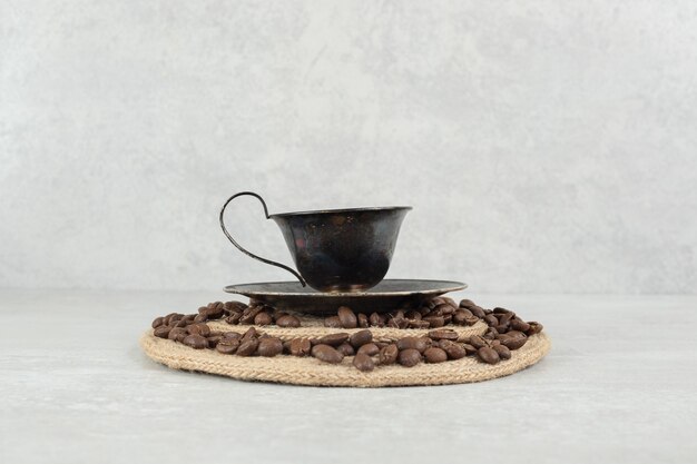 Chicchi di caffè e tazza di caffè su un pezzo di legno