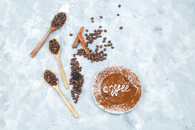 Chicchi di caffè in cucchiai di legno e bastoncini di cannella