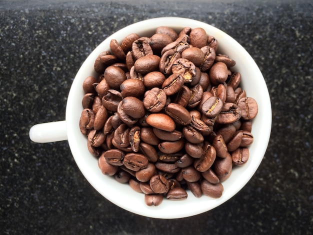 Chicchi di caffè selettivi in ​​grande tazza di caffè. Selettiva concentrata.