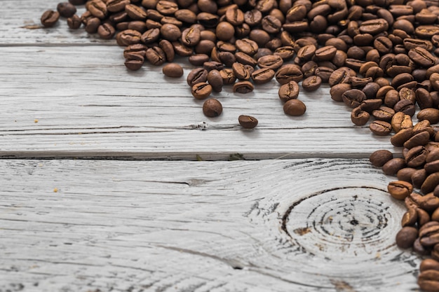 chicchi di caffè su fondo di legno bianco, primo piano