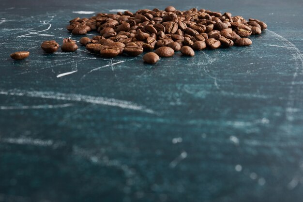 Chicchi di caffè sulla tavola blu.