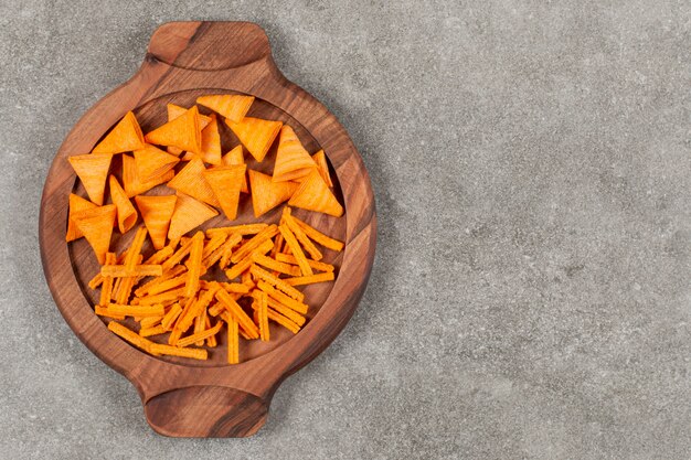 Chip di forma diversa sulla tavola di legno su grigio.