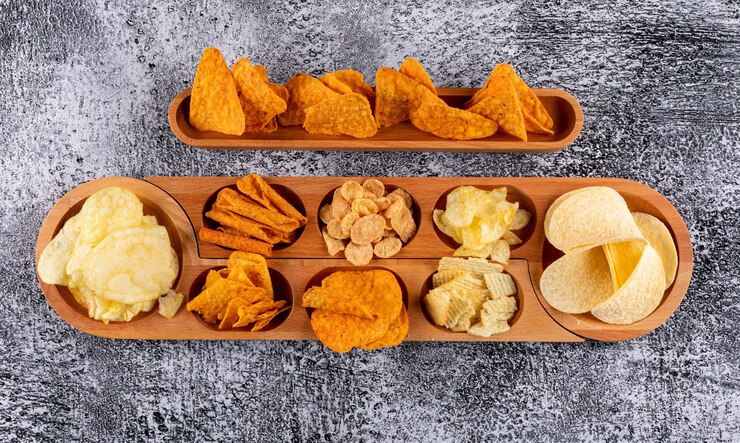 Foto gratuito chip di vista superiore sul piatto di legno con sauses sull'orizzontale di pietra bianco