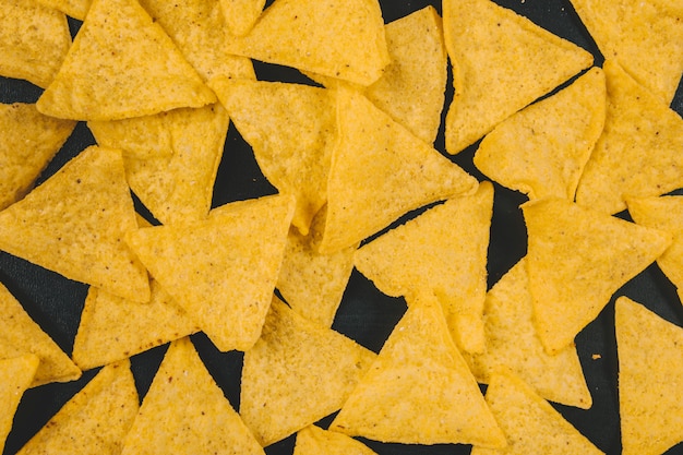 Chip gialli dei nachos messicani sopra priorità bassa nera