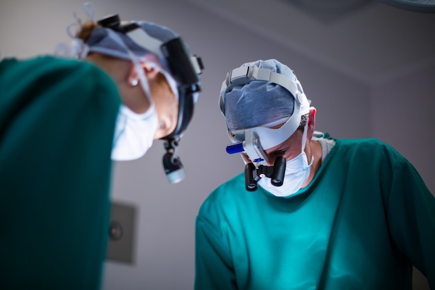 Chirurghi che indossano lenti di ingrandimento chirurgiche durante l'esecuzione dell'operazione