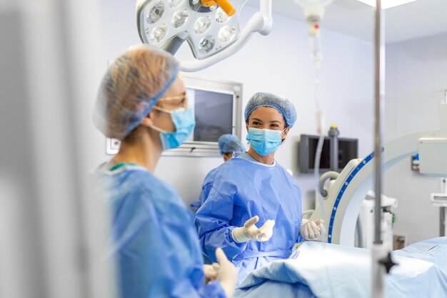 Chirurgo femminile con maschera chirurgica in sala operatoria Giovane dottoressa in uniforme chirurgica in sala operatoria ospedaliera