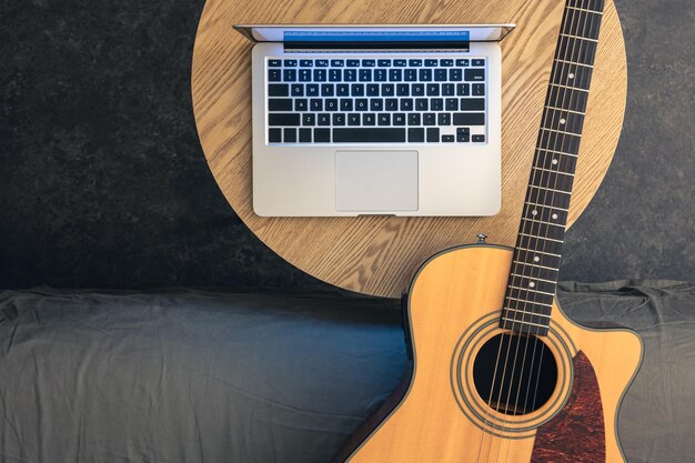 Chitarra acustica e portatile su un tavolo di legno