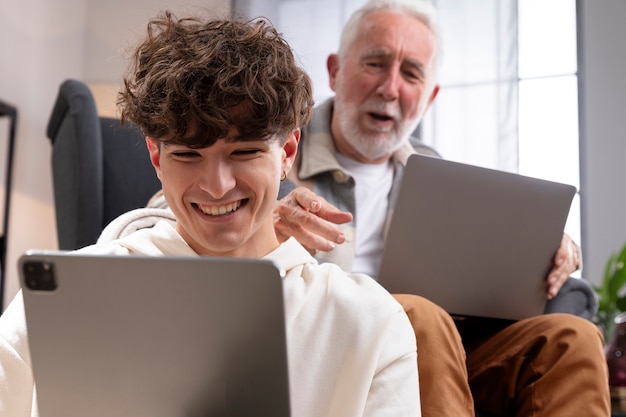 Chiuda in su adolescente sorridente e uomo con i dispositivi