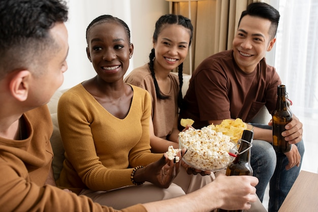 Chiuda in su amici felici con popcorn