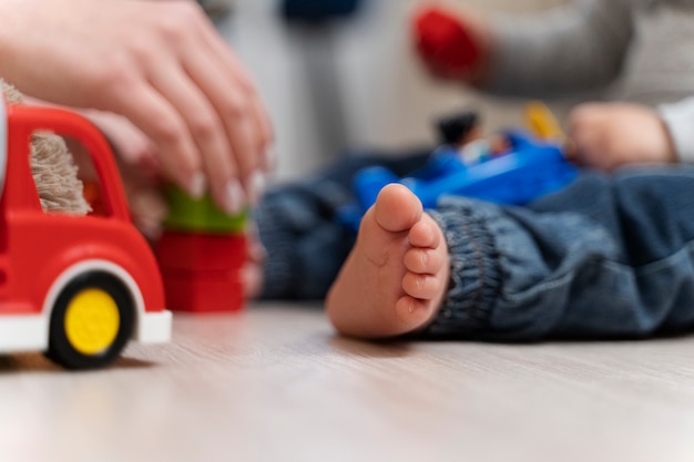 Chiuda in su bambino e genitore che giocano con i giocattoli