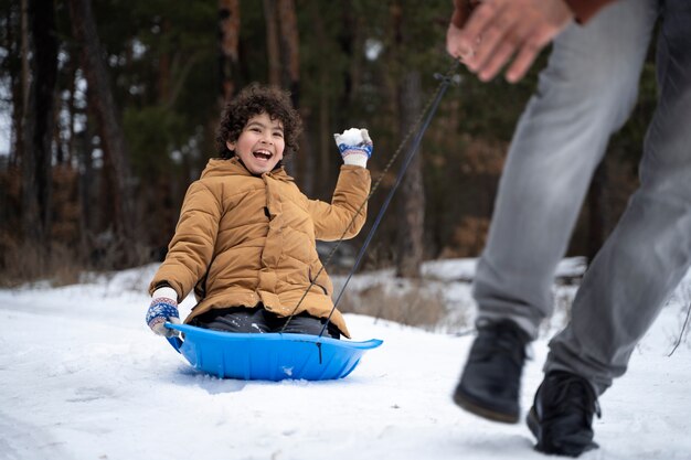 Chiuda in su bambino felice che si diverte con la neve