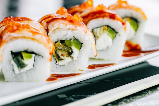 Chiuda in su dei rotoli di sushi con alga del peperone dolce e pesce coperti di gambero