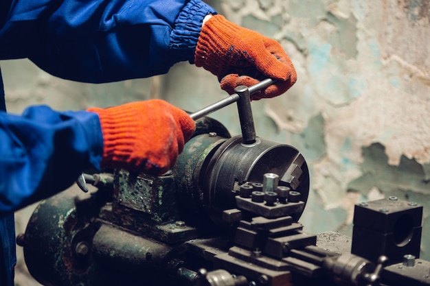 Chiuda in su della mano del riparatore, costruttore professionista che lavora all'interno, riparando