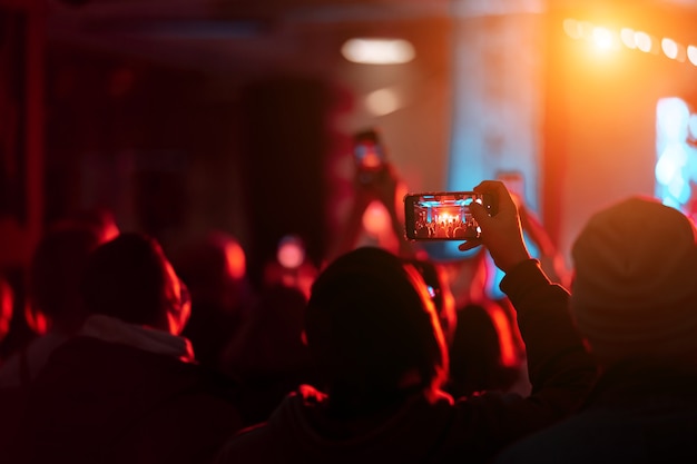 Chiuda in su della registrazione di video con lo smartphone durante un concerto.